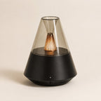 Brume, diffuseur d'ambiance Solveine noir avec dôme effet verre et lumière chaude effet flamme, vue de face sur fond beige