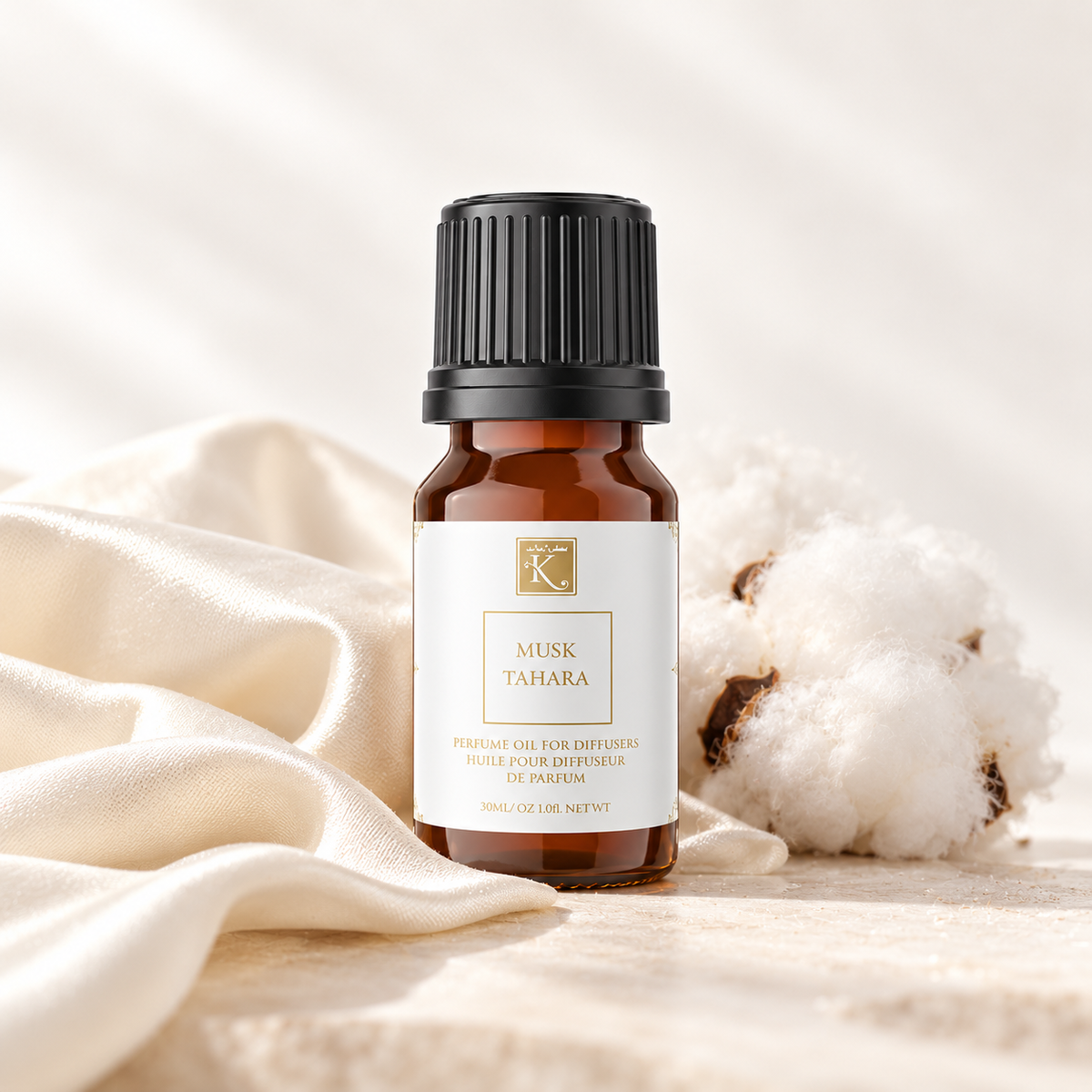 Huile parfumée Musc Tahara 30 ml, mise en scène sur un tissu ivoire pour évoquer la douceur du musc.