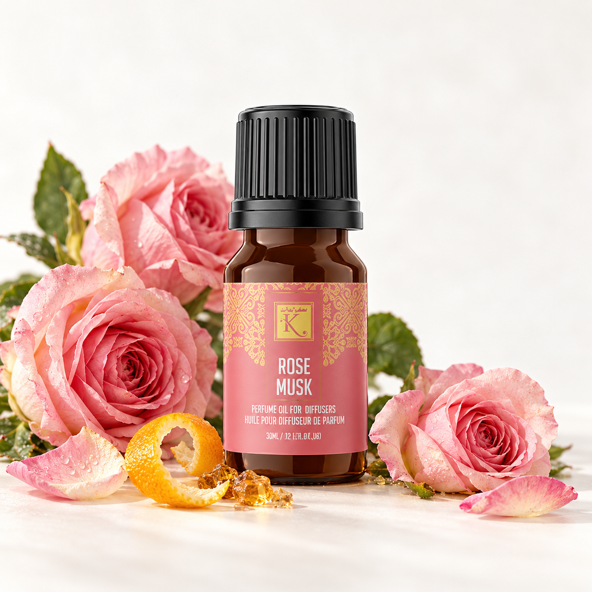 Huile parfumée Rose Musk 30 ml, mise en scène avec des roses, une touche d’agrume et d’ambre pour évoquer ses notes.